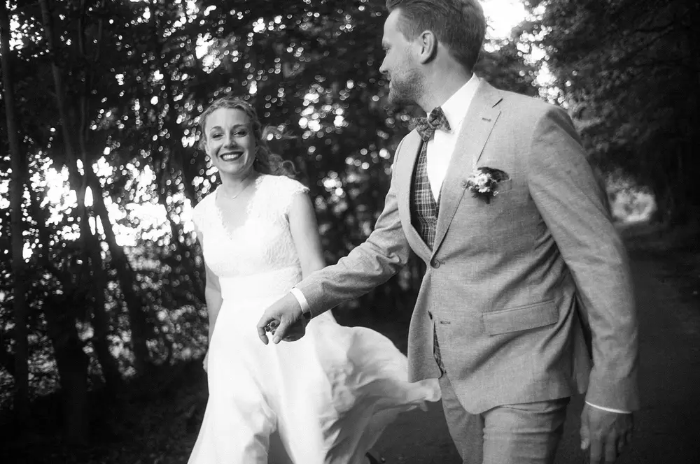 Wedding couple walking through an avenue in Elmshorn. Black and white photo. Leica vintage style. Leica M10 M11.