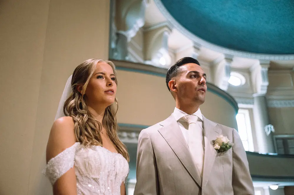 Wedding photography. Couple in a church in Hamburg. Beige suit, white dress. Leica M10 M11.